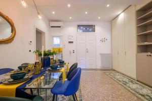 une salle à manger avec une table jaune et des chaises bleues dans l'établissement Residenza Bellavista Design e Vista Mozzafiato, à Bologne