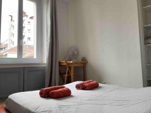 dwa czerwone ręczniki na łóżku w pokoju z oknem w obiekcie R'Apparts T2 Le Chaleureux - Hypercentre - Gare w Grenoble