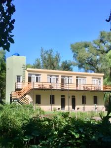 un edificio con balcón y escaleras en la parte delantera en Casablanca La Granja de Capilla, en Capilla del Monte