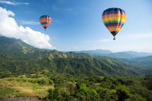 dos globos de aire caliente volando en el cielo sobre las montañas en Hôtel L'Arboisie en Megève