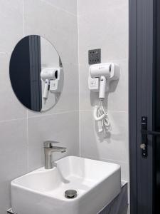 ein Badezimmer mit einem weißen Waschbecken und einem Spiegel in der Unterkunft Lin Hotel and Coffee in Hòa Bình
