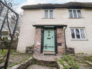 ブリクサムにあるHearthstone East Cottageの緑の扉のある古い石造りの家