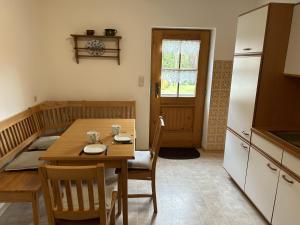 Ferienwohnung Rappl في شليكينغ: مطبخ وغرفة طعام مع طاولة وكراسي خشبية