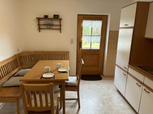 a kitchen and dining room with a wooden table and chairs at Ferienwohnung Rappl in Schleching