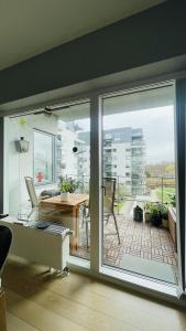 Habitación con una gran puerta corredera de cristal y escritorio. en ApartmentInCopenhagen Apartment 1601 en Copenhague