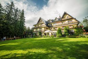 una grande casa con un grande prato davanti di Willa u podnóża Tatr Cztery Pory Roku a Kościelisko