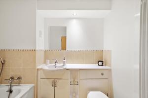 a bathroom with a sink and a toilet and a mirror at Central Bishops Stortford 2BR Apartment in Bishops Stortford