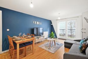 ein Wohnzimmer mit einem Tisch und einer blauen Wand in der Unterkunft Central Bishops Stortford 2BR Apartment in Bishops Stortford