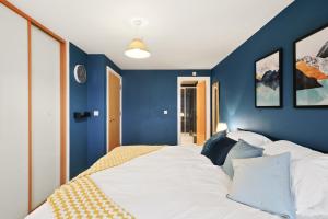 una camera da letto con pareti blu e un grande letto di 2BR Apartment Central Bishops Stortford a Bishops Stortford