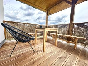 - un hamac sur une terrasse avec une table et un banc dans l'établissement Przystanek Przylasek, à Grywałd