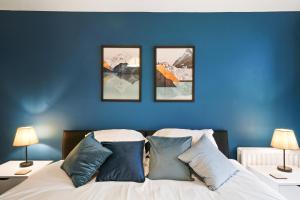 una camera blu con un letto con tre immagini sul muro di 2BR Apartment Central Bishops Stortford a Bishops Stortford