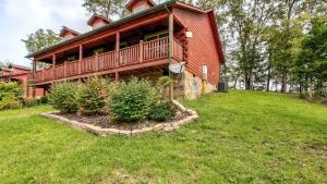 una casa grande con una gran terraza en un campo de césped en Magic Mountain Cabin W Fire Pit & Views Beyond, en Sevierville
