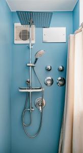 ein Badezimmer mit einer Dusche mit blauer Wand in der Unterkunft FeWo Immenstadt Apartment in Immenstadt im Allgäu