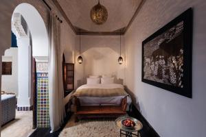 een slaapkamer met een bed en een tafel in een kamer bij Riad Les Yeux Bleus in Marrakesh