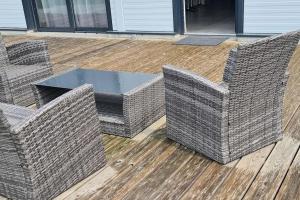 2 chaises en osier et une table sur une terrasse dans l'établissement Super appartement 100m2, à Ribeauvillé
