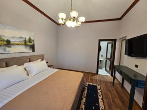 Schlafzimmer mit einem Bett und einem Flachbild-TV in der Unterkunft Vila DANI near Castle and Old Bazar in Kruja