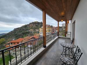 einen Balkon mit einem Tisch und Stühlen sowie Aussicht in der Unterkunft Vila DANI near Castle and Old Bazar in Kruja