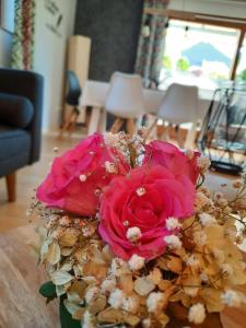 een boeket roze rozen zittend op een tafel bij Fleig Ferienwohnungen in Hecklingen