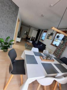 een woonkamer met een witte tafel en stoelen bij Fleig Ferienwohnungen in Hecklingen