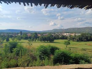 a view of a green field with mountains in the background at At Ease Road Lodge in Zeerust