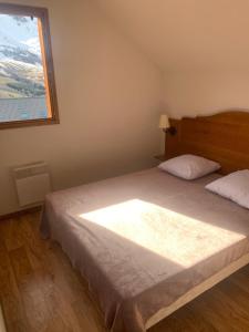 a bedroom with a large bed with a window at Appartement dans Chalet 8 personnes in Albiez-Montrond
