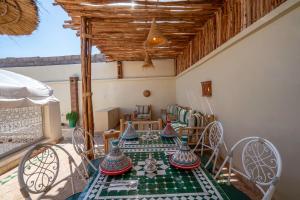 un comedor con una mesa con jarrones. en Riad Chez Henriette en Marrakech