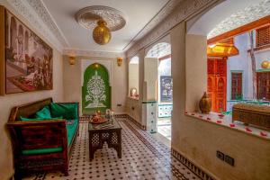 sala de estar con sofá y mesa en una habitación en Riad Chez Henriette en Marrakech