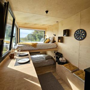 Habitación pequeña con 2 camas y mesa. en Tiny House au milieu des Vignes en Arbis