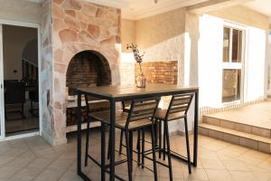 a table and chairs in a room with a fireplace at Villa Paola - Piscine, billard - Au Nord de l'île in Sainte-Marie
