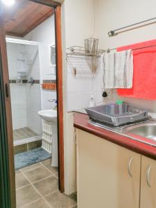 uma pequena casa de banho com um lavatório e um chuveiro em Seaviews Holiday Resort em Jeffreys Bay