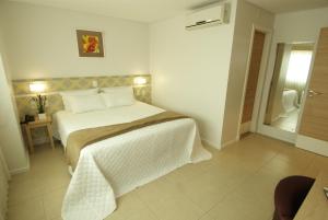 1 dormitorio con 1 cama grande en una habitación en BR Suítes Hotel, en Navegantes
