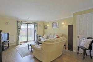 a living room with a couch and a tv at Sparrows, Wangford nr Southwold in Wangford