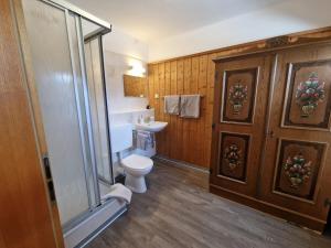 a bathroom with a toilet and a glass shower at Rosy's House Pension Privatzimmer in Bad Goisern