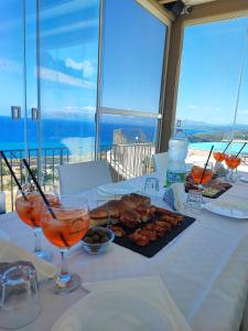 uma mesa com comida e bebidas numa mesa com vista em Hotel Antica Cascina Del Golfo em Scopello