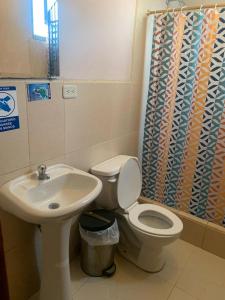 a bathroom with a toilet and a sink at Hospedaje Fenix in Cuenca