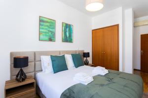 1 dormitorio con cama blanca y almohadas azules en Arts Garden, en Oporto