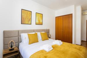 1 dormitorio con 1 cama grande con almohadas amarillas en Arts Garden, en Oporto