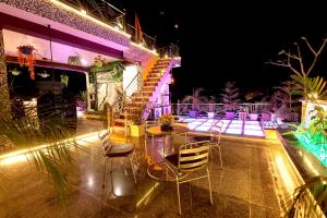 - une terrasse avec une table et des chaises la nuit dans l'établissement Aman Homestay, A Boutique Hotel, à Agra
