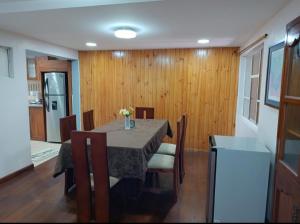comedor con mesa, sillas y paredes de madera en Departamento Gigante de 4 dormitorios. Ecualodge 23, en Cuenca