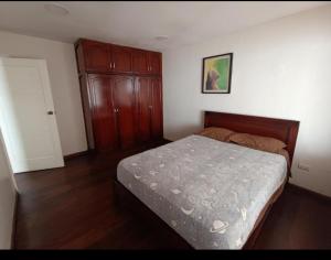 - une chambre avec un lit et une armoire en bois dans l'établissement Departamento Gigante de 4 dormitorios. Ecualodge 23, à Cuenca