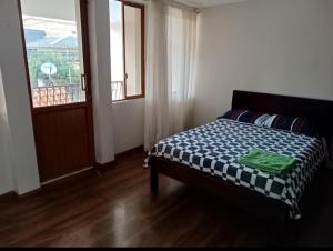 1 dormitorio con cama, ventana y puerta en Departamento Gigante de 4 dormitorios. Ecualodge 23, en Cuenca