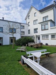 einer Gruppe von Bänken vor einem Gebäude in der Unterkunft Hotel Meeresfriede in Cuxhaven