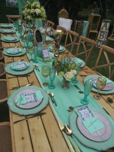 a wooden table with plates and glasses on it at Pebble Fountain Guesthouse in Pretoria