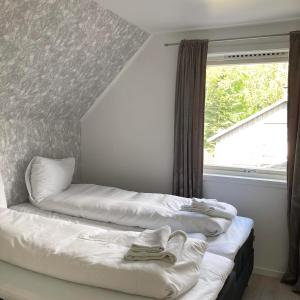 two beds in a room with a window at Store Ringheim Apartment - Villa Hjadlane in Vossevangen