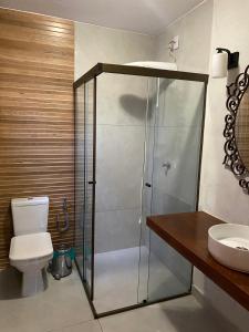 a bathroom with a shower and a toilet and a sink at Casa de Campo Pampulha in Belo Horizonte