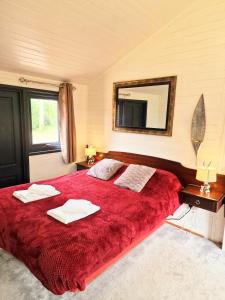 a bedroom with a large red bed with a mirror at Beaver 1 HuntersMoon-warminster-Wiltshire in Warminster