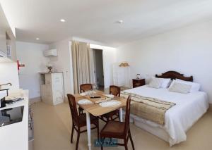 een slaapkamer met een bed en een tafel en stoelen bij MyStay - Casa Matriz Séc XVI in Penafiel
