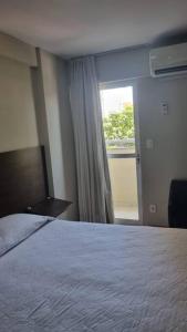 una camera d'albergo con letto e finestra di Mont Blanc Apart Hotel Quarto 102 a Duque de Caxias