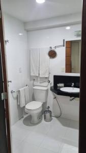 biała łazienka z toaletą i umywalką w obiekcie Mont Blanc Apart Hotel Quarto 102 w mieście Duque de Caxias