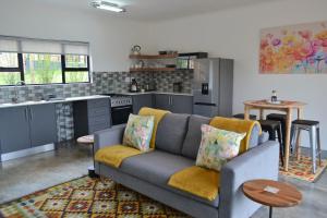 a living room with a couch and a kitchen at Mika Self Catering Cottage in Dullstroom